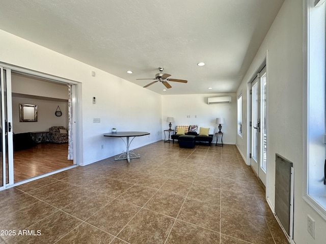 unfurnished room with heating unit, a wall mounted air conditioner, a textured ceiling, dark tile patterned floors, and ceiling fan