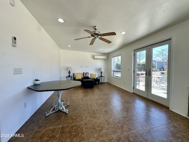 misc room with french doors, ceiling fan, a textured ceiling, and an AC wall unit