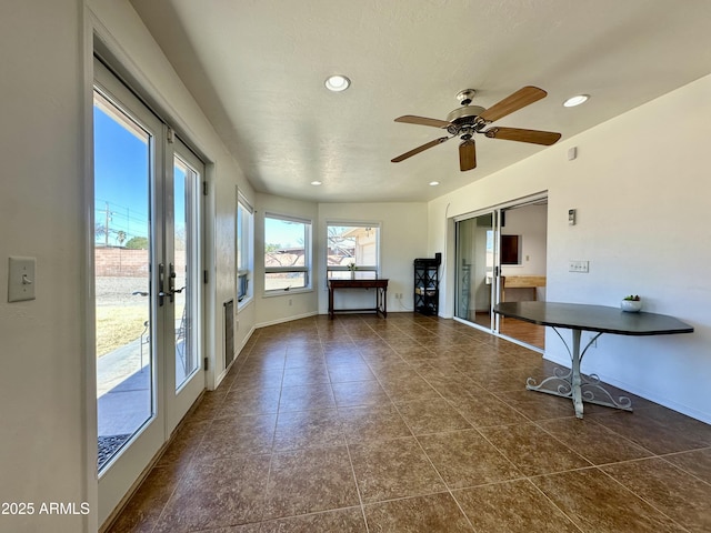 interior space with dark tile patterned flooring, french doors, and ceiling fan