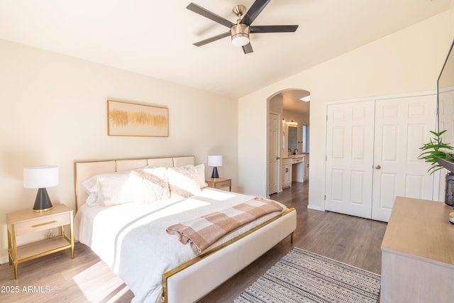 bedroom with lofted ceiling, dark hardwood / wood-style flooring, a closet, ceiling fan, and ensuite bathroom