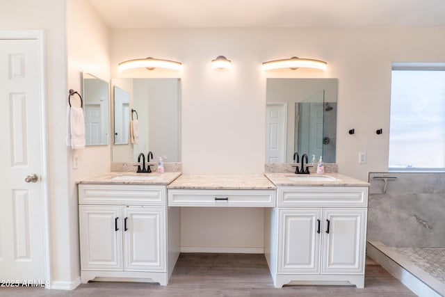 bathroom with a shower, hardwood / wood-style floors, and vanity