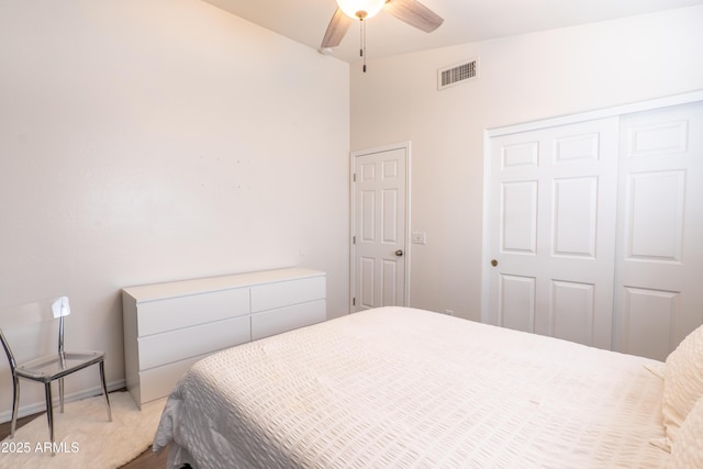 carpeted bedroom featuring ceiling fan, a closet, and vaulted ceiling