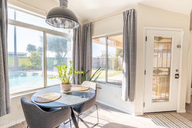 dining room featuring plenty of natural light and lofted ceiling