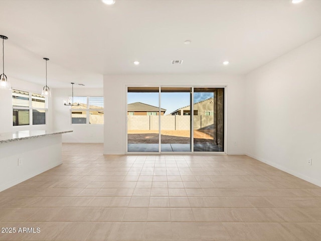 unfurnished room featuring a chandelier and light tile patterned floors