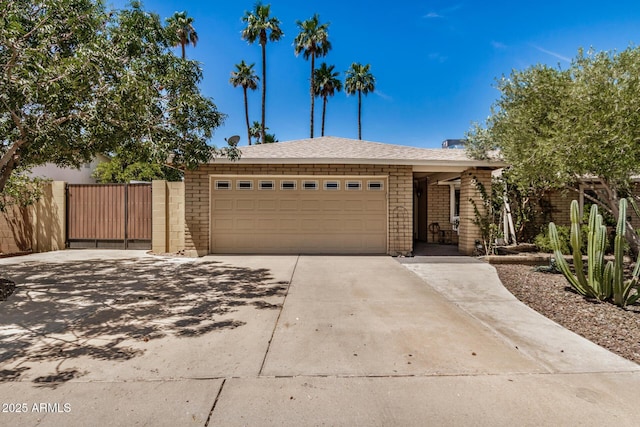 2256 S Las Flores, Mesa, AZ 85202 - view of front of home with driveway, an attached garage, stone siding, and a gate