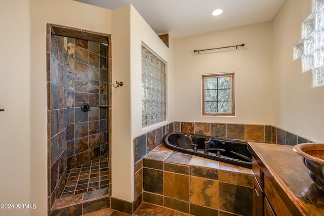 bathroom with vanity and shower with separate bathtub