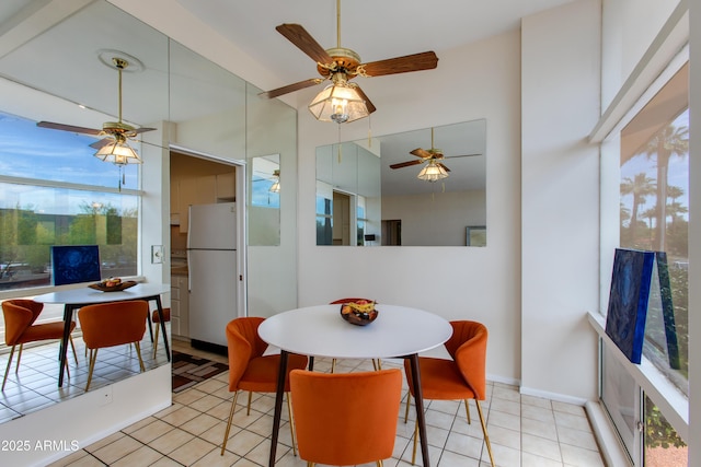 dining area featuring light tile patterned floors, ceiling fan, and a high ceiling