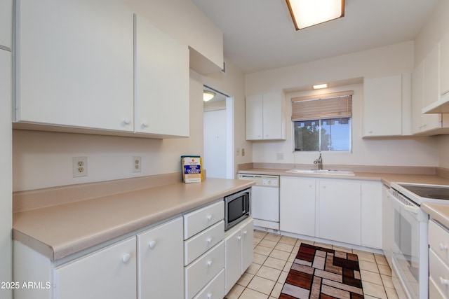 kitchen with white cabinetry, white appliances, light countertops, and a sink