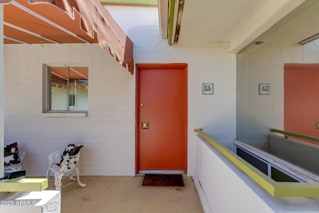 view of exterior entry featuring concrete block siding