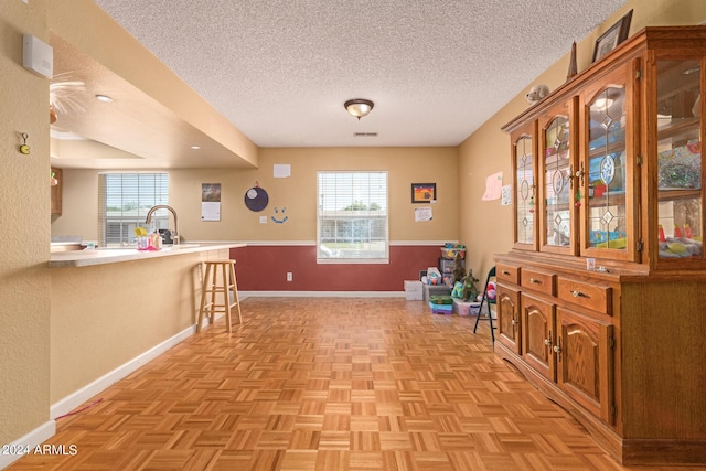 living area with visible vents, a textured ceiling, and baseboards