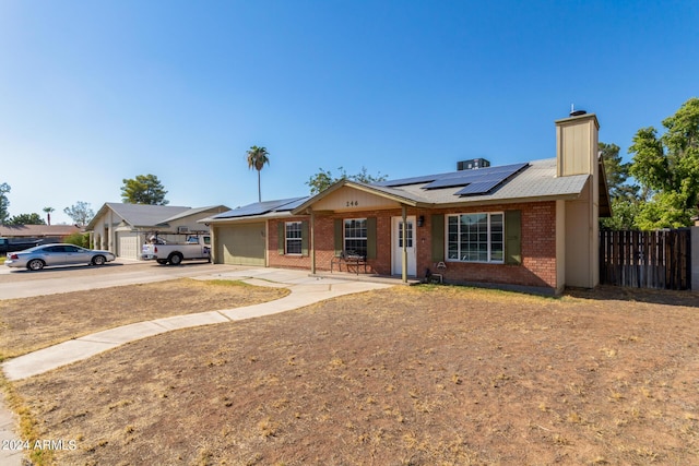 ranch-style home featuring brick siding, a chimney, concrete driveway, fence, and a garage