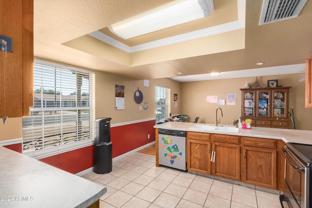 kitchen with visible vents, a raised ceiling, brown cabinets, stainless steel appliances, and a sink