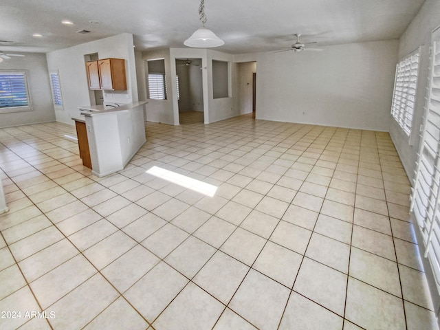 interior space featuring hanging light fixtures, ceiling fan, and light tile flooring