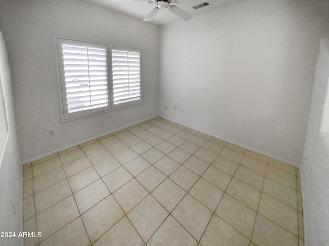 tiled spare room featuring ceiling fan