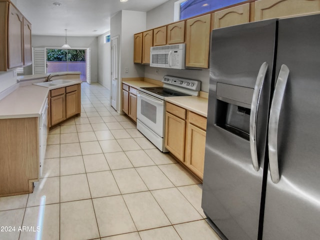 kitchen featuring hanging light fixtures, white appliances, light tile floors, and sink