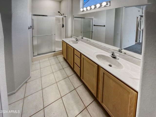 bathroom with oversized vanity, a shower with shower door, double sink, and tile flooring