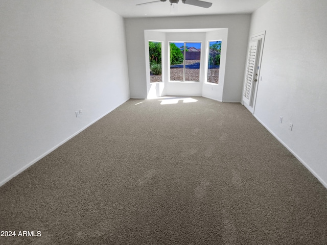 carpeted empty room featuring ceiling fan