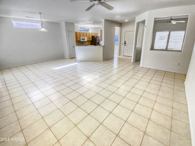 unfurnished living room with ceiling fan and light tile flooring