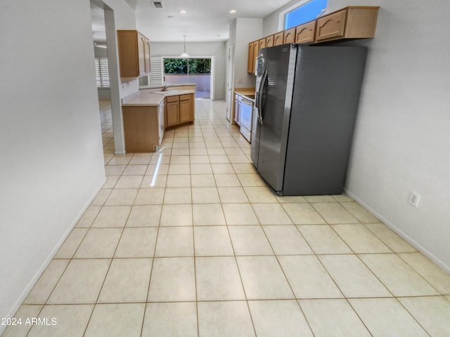 kitchen with stainless steel fridge and light tile floors