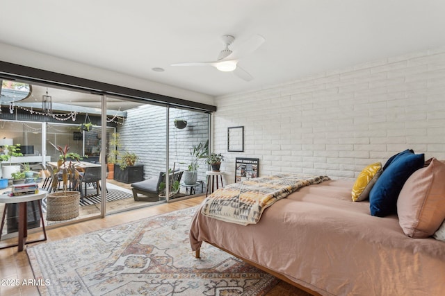 110 W Missouri Ave Unit 18, Phoenix, AZ 85013 - bedroom featuring brick wall, access to exterior, wood finished floors, and a ceiling fan