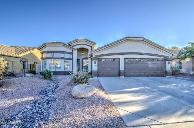 view of front of house featuring an attached garage, a tile roof, concrete driveway, and stucco siding