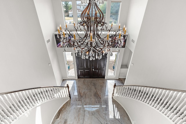 entrance foyer featuring an inviting chandelier and a towering ceiling