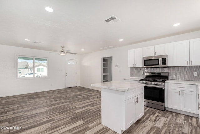 kitchen with white cabinets, ceiling fan, a center island, and appliances with stainless steel finishes