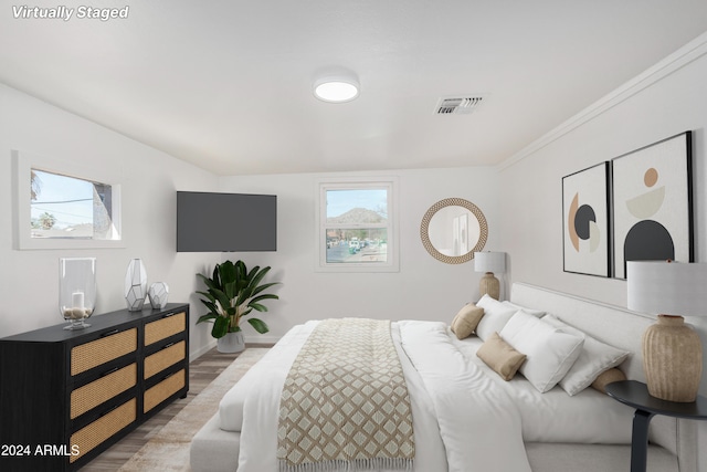 bedroom featuring wood-type flooring and ornamental molding