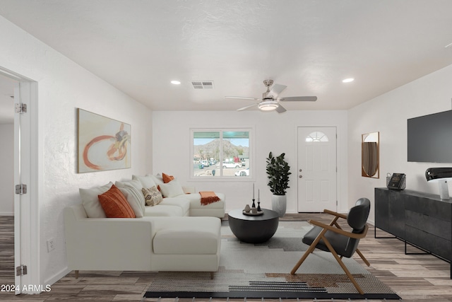 living room featuring ceiling fan and light hardwood / wood-style floors