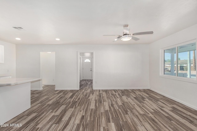 unfurnished living room featuring ceiling fan and dark hardwood / wood-style floors