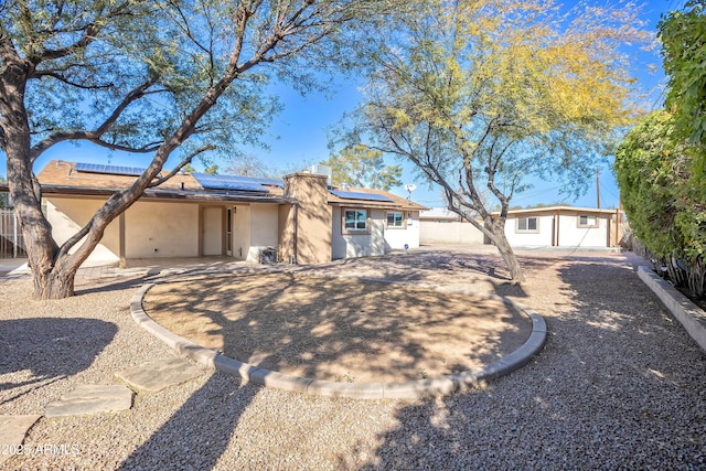 ranch-style home featuring solar panels