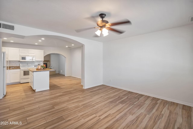 kitchen featuring white cabinetry, white appliances, light hardwood / wood-style flooring, and decorative backsplash