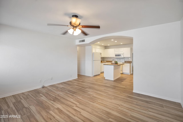 unfurnished living room featuring light hardwood / wood-style flooring and ceiling fan