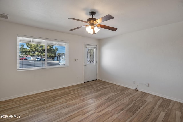 empty room with ceiling fan and light hardwood / wood-style flooring