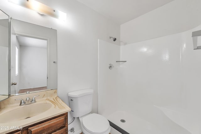 bathroom featuring vanity, walk in shower, and toilet