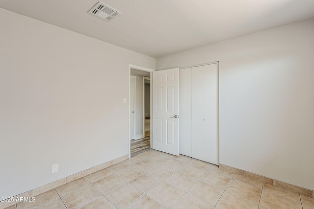 662 W Elena Ave, Mesa, AZ 85210 - unfurnished bedroom with light tile patterned floors, a closet, and baseboards