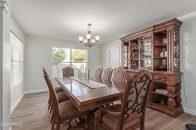 dining room with a notable chandelier and light wood-type flooring