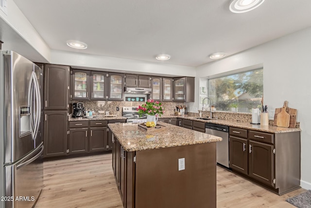 kitchen with sink, dark brown cabinets, stainless steel appliances, and a center island