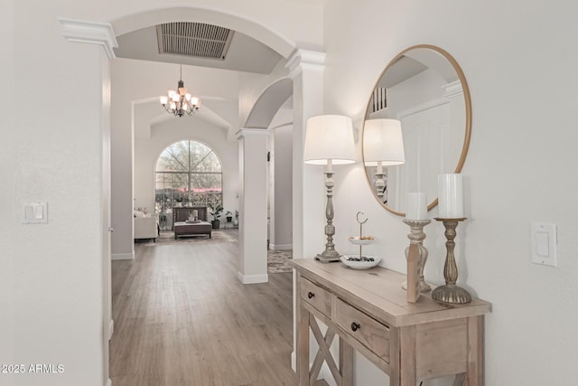 hall with light hardwood / wood-style flooring and a notable chandelier