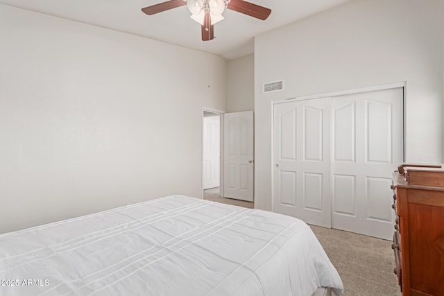 carpeted bedroom featuring ceiling fan and a closet