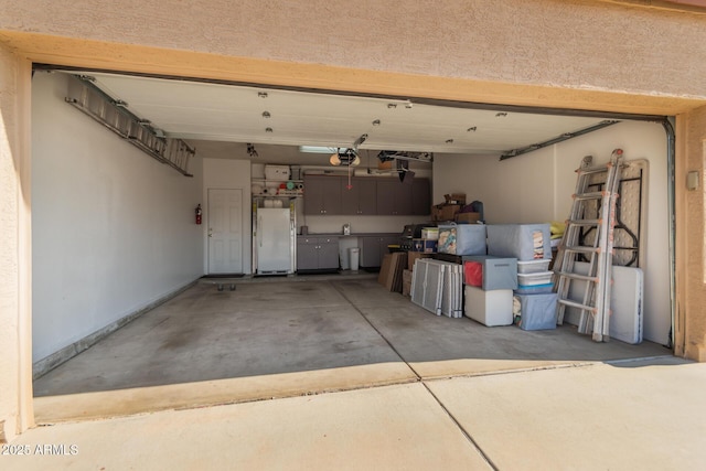 garage with a garage door opener and white fridge