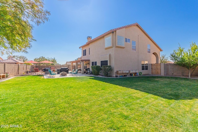 back of house featuring a yard and a patio