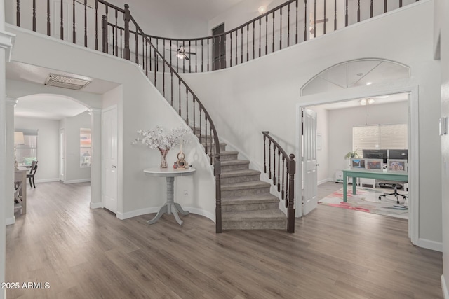 entrance foyer featuring hardwood / wood-style flooring, a high ceiling, a wealth of natural light, and decorative columns