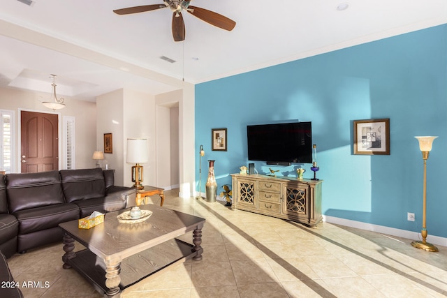 tiled living room with ornamental molding and ceiling fan