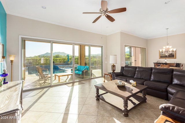 tiled living room with ceiling fan with notable chandelier, a mountain view, and crown molding