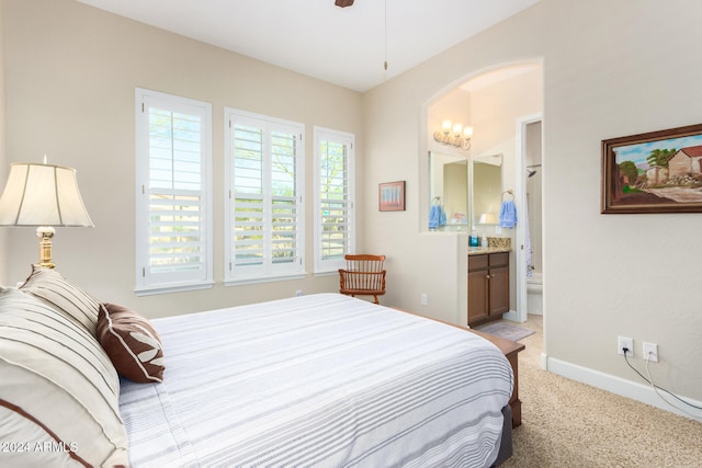 carpeted bedroom featuring ceiling fan and ensuite bath