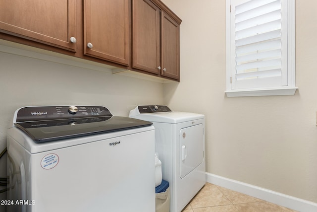 washroom featuring cabinets, light tile patterned floors, and separate washer and dryer