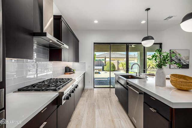 3822 E Canyon Pl, Chandler, AZ 85249 - kitchen featuring stainless steel appliances, wall chimney range hood, light countertops, backsplash, and decorative light fixtures