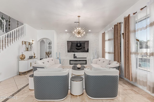 84 E Joseph Way, Gilbert, AZ 85295 - living area featuring arched walkways, a chandelier, light tile patterned flooring, stairway, and a glass covered fireplace