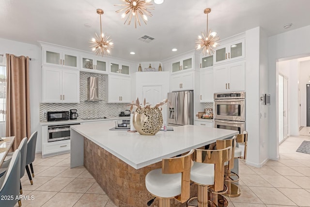 84 E Joseph Way, Gilbert, AZ 85295 - kitchen with stainless steel appliances, wall chimney exhaust hood, a chandelier, light tile patterned floors, and recessed lighting